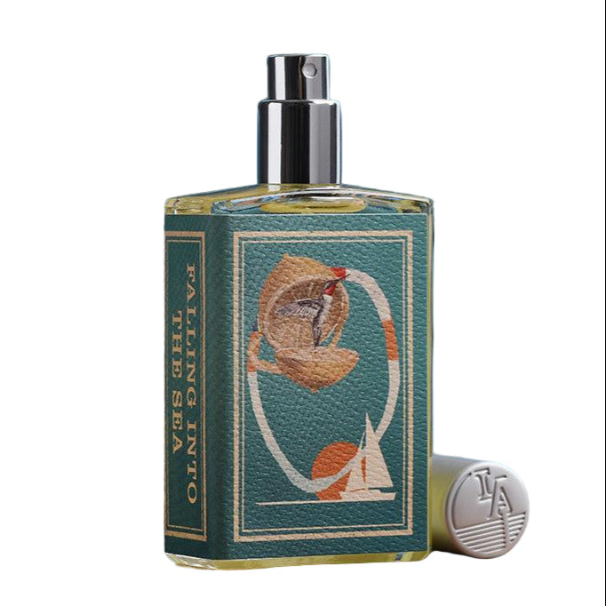 Perfume bottle with decorative label on a wooden surface with books in the background