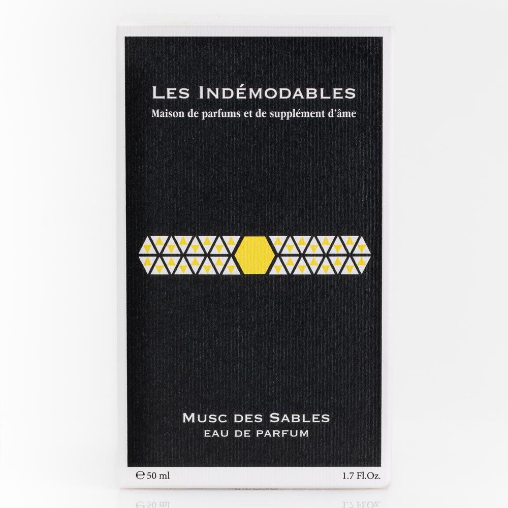 Perfume packaging with 'Les Indémodables' branding on a black background