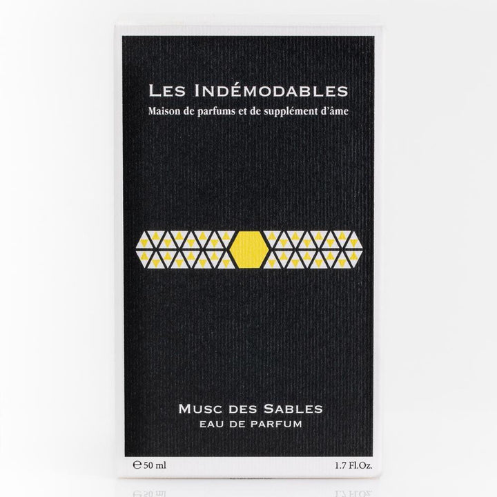 Perfume packaging with 'Les Indémodables' branding on a black background