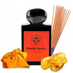 Black bottle of 'Bloody Smoke' with orange label, surrounded by gold leaf and incense sticks on a white background